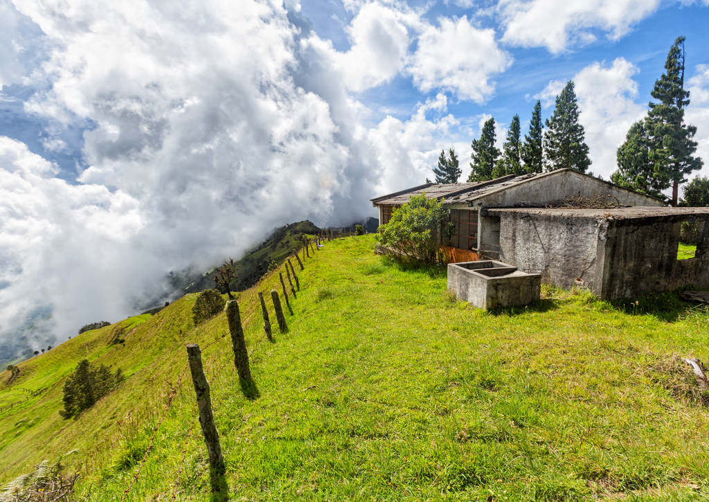 Lais Puzzle - Ein Zaun verschwindet in der Ferne mit Wolken im Hintergrund und einem verlassenen Zementhaus auf einer Bergkuppe zwischen Quindio und Tolima, Kolumbien - 100, 200, 500 & 1.000 Teile p-233753