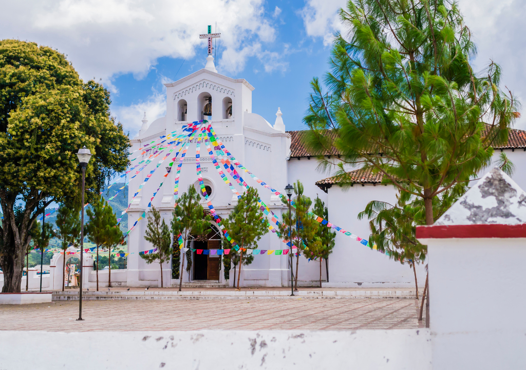 Lais Puzzle - Beeindruckender Blick auf die Kirche San Lorenzo und ihre Vorhalle mit bunten Gebetsfahnen, Zinacantan, Chiapas, Mexiko - 1.000 Teile p-305615