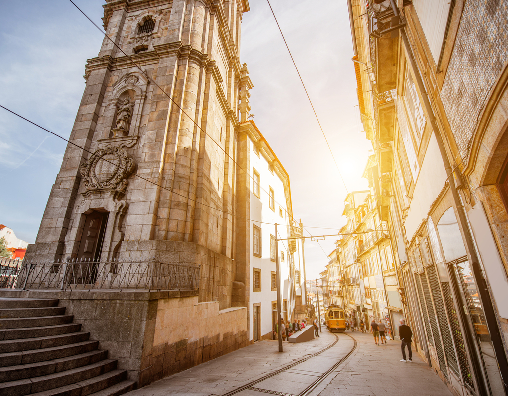 Lais Puzzle - Straßenansicht mit dem Turm der Klerikerkirche mit einer Straßenbahn im Retro-Stil während des Sonnenaufgangs in der Stadt Porto, Portugal - 40, 100, 200, 500, 1.000 & 2.000 Teile p-311683
