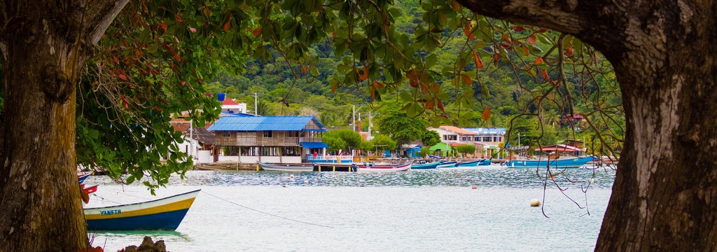 Lais Puzzle - Blauer Strand der Stadt Sapzurro aus einer von Bäumen eingerahmten Ansicht. Kolumbien, Chocó, Panorama - 1.000 Teile p-325739