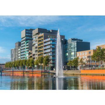 Lais Puzzle - Lelystad: Einheimische gehen und überqueren den Teich mit Brunnen in der Mitte mit modernen Geschäftsgebäuden und Häusern im Hintergrund - 100, 200, 500 & 1.000 Teile