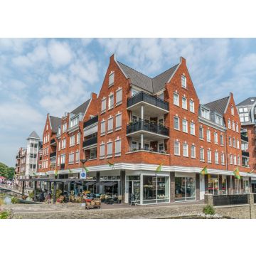 Lais Puzzle - Groesbeek, Die Niederlande - Menschen genießen ein Getränk und Essen vor einem modernen Gebäude mit Restaurant und Geschäften - 100, 200, 500 & 1.000 Teile