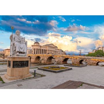 Lais Puzzle - Skopje, Nord-Mazedonien: Statue des byzantinischen Kaisers Justinian und Steinbrücke hinter dem Archäologiemuseum bei Sonnenuntergang in Skopje - 100, 200, 500 & 1.000 Teile