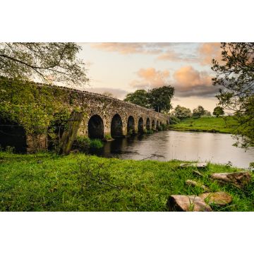 Lais Puzzle - Alte Steinbogenbrücke aus dem 12. Jahrhundert über einen Fluss, Felsen auf der ersten Ebene. Grüne Felder und Bäume. Dramatischer Himmel bei Sonnenuntergang. Grafschaft Meath, Irland - 2.000 Teile