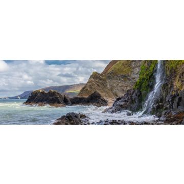 Lais Puzzle - Ein Wasserfall an der walisischen Küste in dem kleinen Fischerdorf Tresaith. Das Meer ist wild, ebenso wie der weiß-blaue Wolkenhimmel. Im Hintergrund die hohen Klippen, Panorama - 1.000 Teile