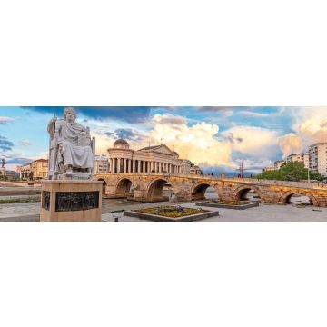 Lais Puzzle - Skopje, Nord-Mazedonien: Statue des byzantinischen Kaisers Justinian und Steinbrücke hinter dem Archäologiemuseum bei Sonnenuntergang in Skopje, Panorama - 1.000 Teile