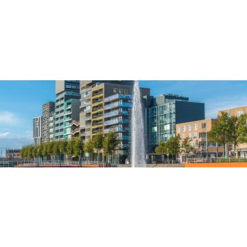 Lais Puzzle - Lelystad: Einheimische gehen und überqueren den Teich mit Brunnen in der Mitte mit modernen Geschäftsgebäuden und Häusern im Hintergrund, Panorama - 1.000 Teile