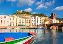 Lais Puzzle - Buntes Boot vor dem Hintergrund der schönen Gebäude von Bosa, Sardinien, Italien - 100, 200, 500 & 1.000 Teile