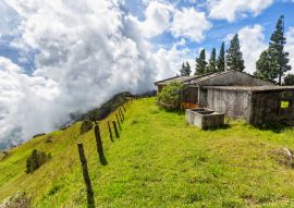 Lais Puzzle - Ein Zaun verschwindet in der Ferne mit Wolken im Hintergrund und einem verlassenen Zementhaus auf einer Bergkuppe zwischen Quindio und Tolima, Kolumbien - 100, 200, 500 & 1.000 Teile