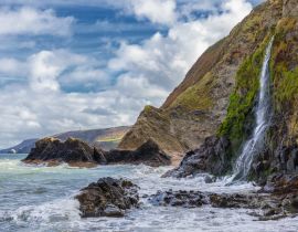 Lais Puzzle - Ein Wasserfall an der walisischen Küste in dem kleinen Fischerdorf Tresaith. Das Meer ist wild, ebenso wie der weiß-blaue Wolkenhimmel. Im Hintergrund die hohen Klippen - 40 Teile