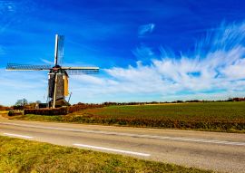 Lais Puzzle - Windmühle neben einer Straße und einem Anbaufeld an einem wunderschönen sonnigen Tag mit blauem Himmel mit reichlich weißen Wolken in einer unregelmäßigen Form in Beek Süd-Limburg in den Niederlanden - 100, 200, 500 & 1.000 Teile