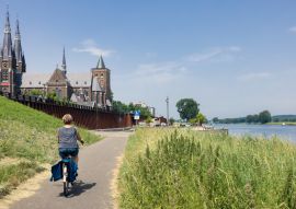 Lais Puzzle - Frau radelt entlang der Maas in der Nähe des niederländischen Dorfes Cuijk - 100, 200, 500 & 1.000 Teile