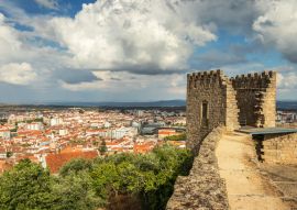 Lais Puzzle - Schlossturm von Castelo Branco, Portugal, mit der Stadt im Hintergrund und einem Himmel mit großen Wolken - 100, 200, 500 & 1.000 Teile