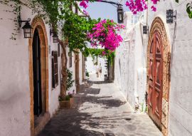 Lais Puzzle - Enge Straße in der Stadt Lindos auf der Insel Rhodos, Dodekanes, Griechenland. Schöne malerische alte weiße Häuser mit Blumen. Berühmtes Touristenziel in Südeuropa - 100, 200, 500 & 1.000 Teile