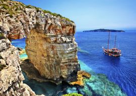 Lais Puzzle - Touristenboot auf dem Weg zum Trypitos (auch bekannt als "Kamara"), einem natürlichen Felsbogen auf der Insel Paxos, Ionisches Meer, Griechenland. Im Hintergrund die Insel Antipaxos - 100, 200, 500 & 1.000 Teile