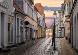 Lais Puzzle - Eine schöne bunte Straße bei Sonnenuntergang in Viborg, Dänemark. Schöne Stadt Straße in Dänemark. Dänemark Stadtbild in der Abenddämmerung. Skandinavische Straße bei Sonnenuntergang. Viborg ist eine der ältesten Städte Dänemarks - 100...