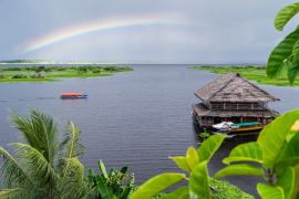 Lais Puzzle - Blick auf den Nebenfluss des Amazonas in Iquitos, Peru. Ein Regenbogen über dem Fluss und ein wunderschönes Gebäude, das auf dem Wasser schwimmt - 2.000 Teile