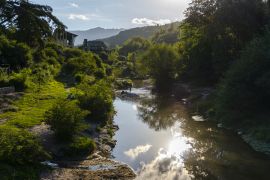 Lais Puzzle - Blick auf den Sonnenuntergang in den Bergen, der das Sonnenlicht auf dem Fluss während der Sommersaison in La Cumbrecita, Cordoba, Argentinien reflektiert - 2.000 Teile