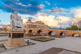 Lais Puzzle - Skopje, Nord-Mazedonien: Statue des byzantinischen Kaisers Justinian und Steinbrücke hinter dem Archäologiemuseum bei Sonnenuntergang in Skopje - 2.000 Teile
