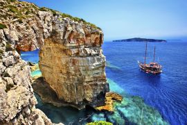 Lais Puzzle - Touristenboot auf dem Weg zum Trypitos (auch bekannt als "Kamara"), einem natürlichen Felsbogen auf der Insel Paxos, Ionisches Meer, Griechenland. Im Hintergrund die Insel Antipaxos - 2.000 Teile
