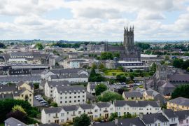 Lais Puzzle - Blick über die Stadt Kilkenny, Irland, vom runden Turm der St Canice's Cathedral mit einer Mischung aus moderner und mittelalterlicher Architektur unter einem bewölkten Himmel und der St Mary's Cathedral, die sich über der Stadt erhebt...