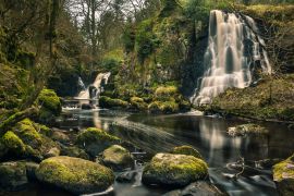 Lais Puzzle - Langzeitbelichtungsaufnahme der Linn Jaw Wasserfälle, in der Nähe von Livingston, Schottland, mit moosbewachsenen Felsen im Vordergrund und rund um die Wasserfälle und weißen Schaumstreifen im Wasser. West Lothian. UK - 2.000 Teile