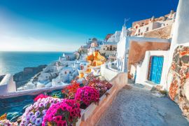 Lais Puzzle - Santorin, Griechenland. Bilderq Ansicht traditioneller kykladischer Santorini-Häuser an einer kleinen Straße mit Blumen im Vordergrund. Standort: Oia Dorf, Santorini, Griechenland - 2.000 Teile