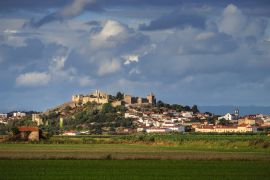 Lais Puzzle - Von der Sonne beleuchtete Burg und Häuser von Montemor-o-Velho, von den Reisfeldern aus gesehen, mit einem Himmel voller Wolken. Montemor-o-Velho in Portugal - 2.000 Teile