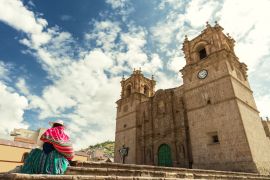 Lais Puzzle - Frau mit Keperina (Tasche auf dem Rücken) auf den Stufen der Kathedrale von Puno (Peru) sitzend - 2.000 Teile