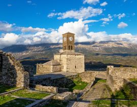 Lais Puzzle - Blick auf den Uhrenturm der Burg von Gjirokastra mit Bergen und Wolken - 40, 100, 200, 500, 1.000 & 2.000 Teile