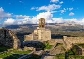 Lais Puzzle - Blick auf den Uhrenturm der Burg von Gjirokastra mit Bergen und Wolken - 1.000 Teile