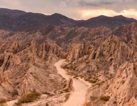 Lais Puzzle - Die berühmte Straße Ruta 40 bei Sonnenuntergang, die sich durch die geologischen Wunder der Quebrada de Las Flechas, Valles Calchaquíes, Salta, Nordwest-Argentinien, schlängelt - 40, 100, 200, 500, 1.000 & 2.000 Teile