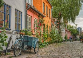 Lais Puzzle - An einem Sommertag parkt ein typisch dänisches Cargo-Bike, besser bekannt als Christiania Bike, am Eingang eines Hauses in einer gemütlichen, gepflasterten Straße, die Gemütlichkeit und ein kulturelles Konzept vermittelt - Aarhus, D...