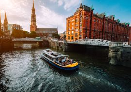 Lais Puzzle - Touristisches Kreuzfahrtschiff auf einem Kanal mit Brücken in der alten Speicherstadt in Hamburg im goldenen Licht des Sonnenuntergangs, Deutschland - 1.000 Teile