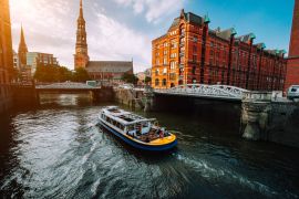 Lais Puzzle - Touristisches Kreuzfahrtschiff auf einem Kanal mit Brücken in der alten Speicherstadt in Hamburg im goldenen Licht des Sonnenuntergangs, Deutschland - 2.000 Teile