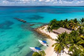 Lais Puzzle - Luftaufnahme einer Drohne vom paradiesischen Strand mit altem, kaputtem Pier, Booten, Palmen und blauem Wasser des Karibischen Meeres mit transparentem Korallenboden, Insel Saona, Dominikanische Republik - 2.000 Teile