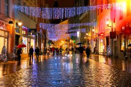 Lais Puzzle - Rainy Autumn Travel to Europe in the City Christmas Tallinn Old town street night light people walking with umbrellas rain drops reflection on wet asphalt soft blurred light lifestyle Tilt Shift - 2.000 Teile