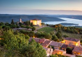 Lais Puzzle - Blick auf das Dorf Aiguines mit charmantem Schloss und Kirche mit Blick auf den See Lac de Sainte Croix, Departement Var, Provence, Frankreich - 1.000 Teile