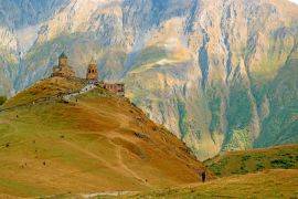Lais Puzzle - Atemberaubende Aussicht auf die Dreifaltigkeitskirche von Gergeti oder Tsminda Sameba auf dem Hügel mit einer Besuchergruppe, Stadt Stepantsminda, Georgien - 2.000 Teile