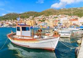 Lais Puzzle - Traditionelles griechisches Boot im Hafen von Samos mit bunten Häusern im Hintergrund, Griechenland - 1.000 Teile