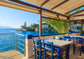 Lais Puzzle - Blaue Stühle mit Tischen in einer traditionellen griechischen Taverne im Hafen von Fiskardo, Insel Kefalonia, Griechenland - 1.000 Teile