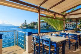 Lais Puzzle - Blaue Stühle mit Tischen in einer traditionellen griechischen Taverne im Hafen von Fiskardo, Insel Kefalonia, Griechenland - 2.000 Teile