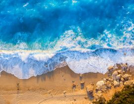 Lais Puzzle - Blick von oben auf den goldenen Strand und das leuchtend blaue Meer von Milos Beach auf der Insel Lefkada, Griechenland, mit hohen Wellen und langen Schatten während des Sonnenuntergangs im Sommer - 40, 100, 200, 500, 1.000 & 2.000 Teile