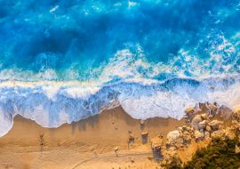 Lais Puzzle - Blick von oben auf den goldenen Strand und das leuchtend blaue Meer von Milos Beach auf der Insel Lefkada, Griechenland, mit hohen Wellen und langen Schatten während des Sonnenuntergangs im Sommer - 1.000 Teile