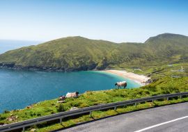 Lais Puzzle - Schafe auf einer Klippe im Fokus, Keem Strand außerhalb des Fokus, Achill Insel in der Grafschaft Mayo, Irland, warmer sonniger Tag. Klarer blauer Himmel und Wasser des Atlantischen Ozeans. Irische Landschaft - 1.000 Teile