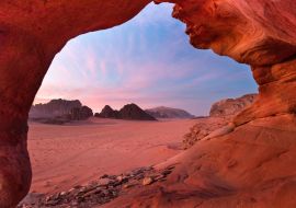 Lais Puzzle - Blick durch einen roten Steinbogen in die wunderschöne Abenddämmerung in der Wüste Wadi Rum in Jordanien - 1.000 Teile