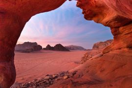 Lais Puzzle - Blick durch einen roten Steinbogen in die wunderschöne Abenddämmerung in der Wüste Wadi Rum in Jordanien - 2.000 Teile