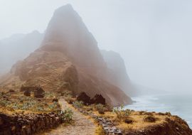 Lais Puzzle - Insel Santo Antao, Kap Verde. Panoramablick auf den Aranhas-Gipfel im Tal mit Hausruinen und steinigem Wanderweg - 1.000 Teile