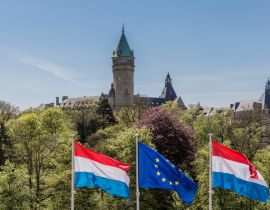 Lais Puzzle - Flaggen der Europäischen Union und Luxemburgs mit dem Bankenmuseum im Hintergrund, sonniger Tag mit blauem Himmel in Luxemburg - 40, 100, 200, 500, 1.000 & 2.000 Teile
