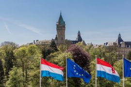 Lais Puzzle - Flaggen der Europäischen Union und Luxemburgs mit dem Bankenmuseum im Hintergrund, sonniger Tag mit blauem Himmel in Luxemburg - 2.000 Teile